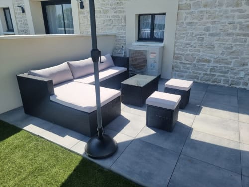 Espace de détente du Gîtes Les Camelias 71 avec mobilier en rotin noir, transats et parasol à Oslon, France