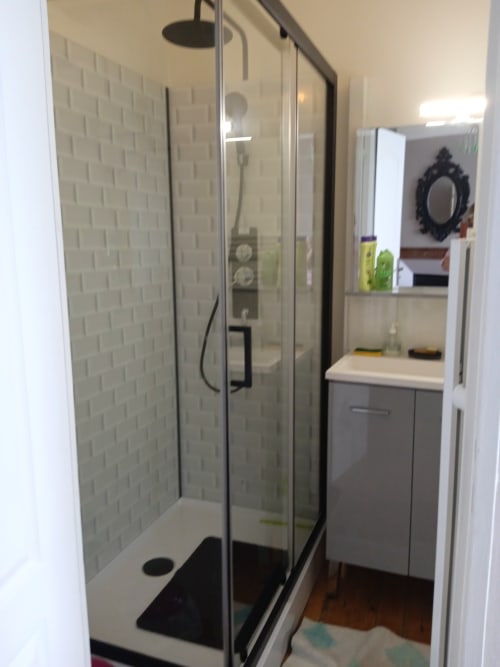 Salle de bain moderne avec douche à l'italienne, meuble-vasque gris et carrelage blanc métro à l'hôtel Les Clématites en Cotentin, Saint-Floxel