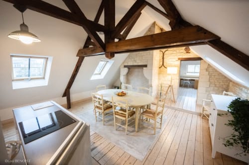 Spacieuse chambre loft à la Villa République Normandie à Caen avec poutres apparentes, coin repas et cheminée en pierre