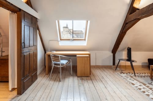 Chambre mansardée à la Villa République Normandie à Caen avec lucarne, poutres apparentes, bureau et vue sur la ville