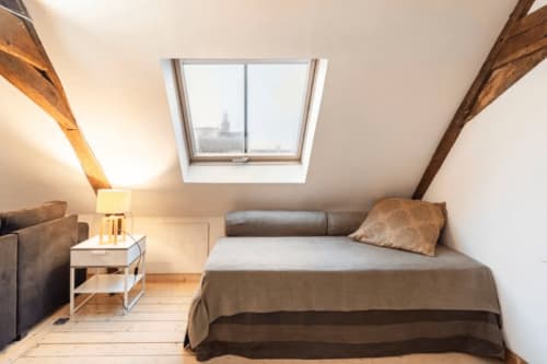 Chambre douillette sous les toits à la Villa République Normandie, Caen avec verrière, poutres apparentes et mobilier moderne