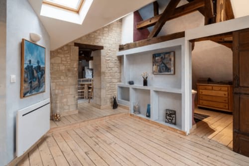Loft contemporain à Villa République Normandie à Caen avec poutres apparentes, parquet et étagères blanches