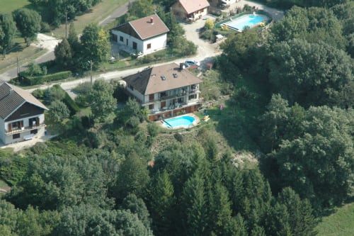 Vue aérienne des Gîtes Des Planchettes à Marigny, France, montrant deux maisons avec piscines entourées de forêt