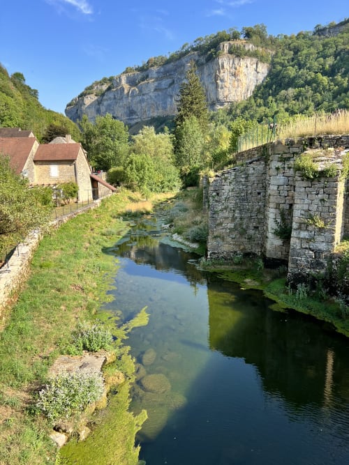 Vue pittoresque de la rivière aux Gîtes Des Planchettes à Marigny avec pont de pierre et falaises calcaires