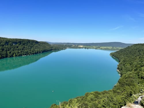 Lac turquoise entouré de collines boisées près des Gîtes Des Planchettes, Marigny