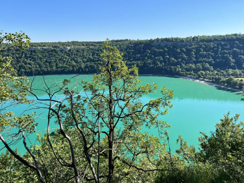 Lac turquoise entouré d'une forêt verdoyante près des Gîtes Des Planchettes à Marigny