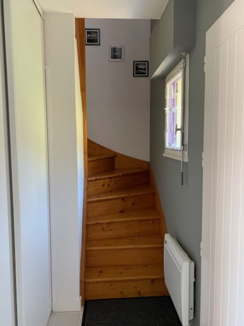 Escalier en bois dans un charmant appartement de Belle Île aux murs gris et tableaux encadrés