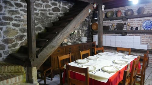 Comedor rústico del Hotel Rural Los Texos con muros de piedra, vigas de madera y mesa preparada para huéspedes en La Riera de Covadonga