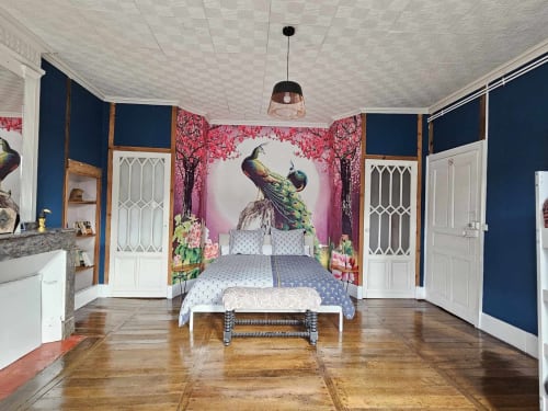 Luxuriöses Pfauen-Themenzimmer in der Bastide du Thoré mit marineblauem Wand, verziertem Bett und künstlerischer Tapete