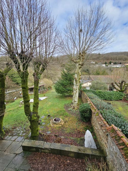 Üppiger Garten der Bastide du Thoré mit kahlen Weiden, Steinmauern und Landschaftsblicken in Labastide-Rouairoux