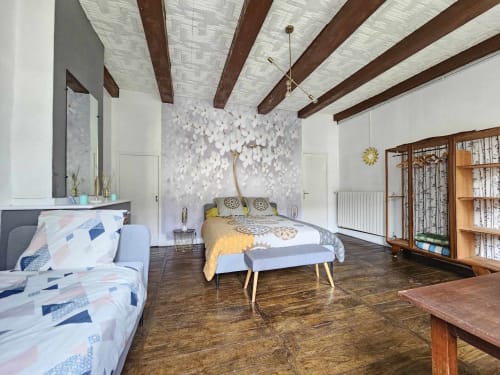 Geräumiges Dreierzimmer mit sichtbaren Holzbalken, strukturierter weißer Wandkunst und Gartenblick in der Bastide du Thoré