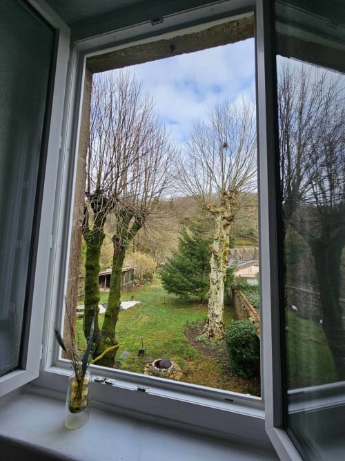 Gartenblick aus dem FLOWER-Zimmer der Bastide du Thoré mit kahlen Bäumen, grünem Rasen und Hügellandschaft