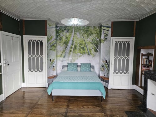 Chambre Bambou à la Bastide du Thoré avec fresque forestière, literie turquoise, portes blanches et parquet à Labastide-Rouairoux