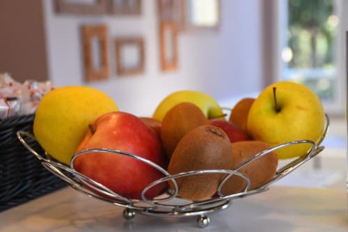 Fresh fruit bowl with apples and kiwis in Hotel Fiori's elegant Roma lobby decor