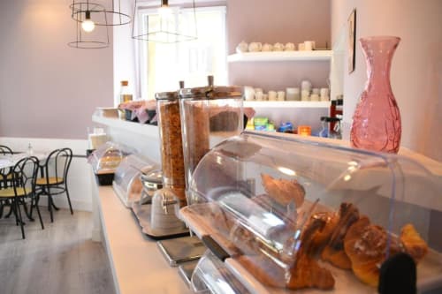 Hotel Fiori Roma cafe counter with pastries, coffee equipment, and pink accents in modern interior