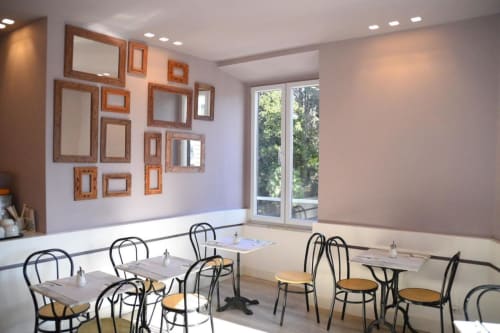 Sala de comedor moderna en Hotel Fiori Roma con espejos de marco de madera, mesas con sillas negras y grandes ventanales con vistas