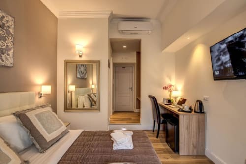 Camera moderna Chester Suites Roma con letto matrimoniale, scrivania da lavoro, TV a schermo piatto e riflesso nello specchio