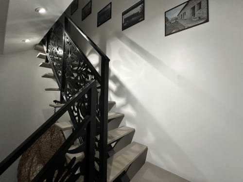 Escalier moderne avec rampe ornementale noire aux Gites Les Camelias 71 à Oslon, marches blanches et encadrées