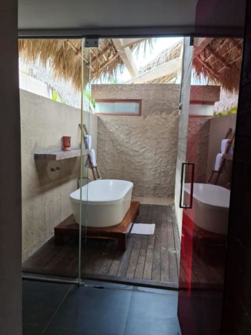 Außenbadezimmer im Isla Tajín Beach & River Resort mit freistehender weißer Badewanne auf Holzterrasse und Steinmauern
