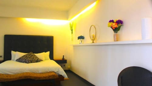 Modernes Hotelzimmer im Isla Tajín Beach & River Resort in Tuxpan mit gelbem Umgebungslicht, schwarzem Kopfbrett und weißem