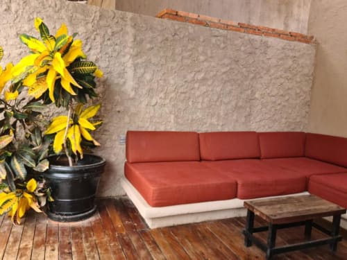 Modernes rotes Ecksofa in einem Zimmer mit Gartenblick im Isla Tajín Beach & River Resort, Tuxpan, mit gelbblühender Pflanze