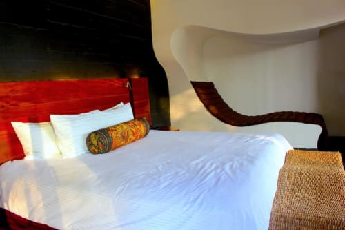 Modernes Schlafzimmer im Isla Tajín Beach & River Resort in Tuxpan mit rotem Kopfteil, weißer Bettwäsche und geschwungener weißer Architektur