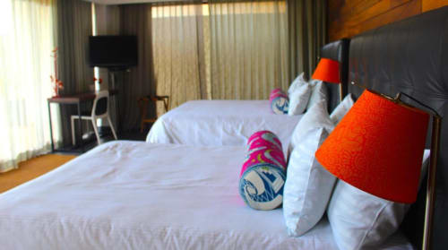 Modernes Hotelzimmer im Isla Tajín Beach & River Resort in Tuxpan mit Doppelbetten, orangefarbenen Akzentleuchten und Meerblick