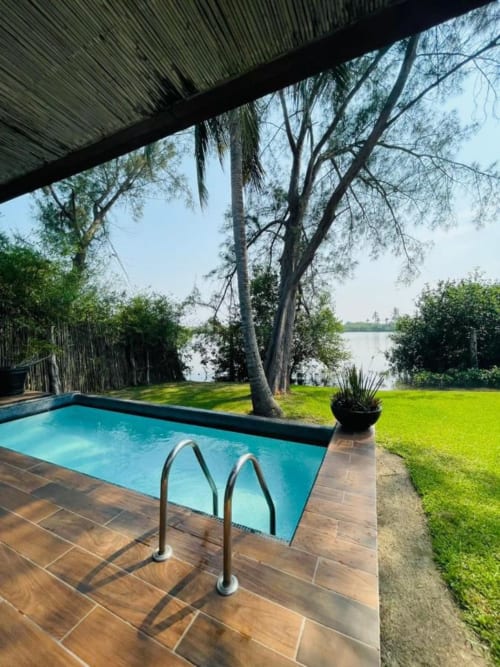 Isla Tajín Beach & River Resort pool overlooking the Tuxpan River with palm trees and lush grounds