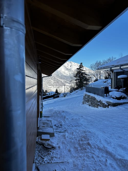 Vue enneigée des pics alpins depuis la terrasse du Chalet d'hôtes Les Louettes à Saxon, ciel dégagé
