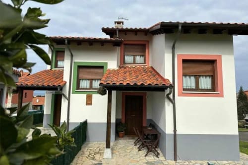 Esto si es vida apartment in Ribadesella with white walls, colorful doors, and terracotta roof