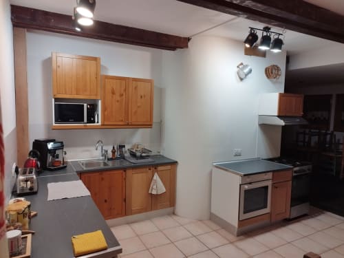 Área de cocina en el BnB L'étape Du Fanfoué en Chamrousse con gabinetes de madera, electrodomésticos de acero inoxidable y mostrador comedor