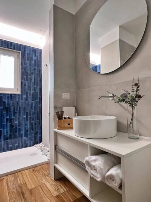 Bagno moderno a Finella Charming Rooms a Bari con lavabo rotondo, doccia con piastrelle blu e pavimento in legno