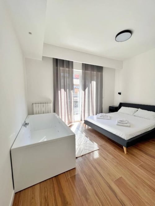 Camera moderna a Finella Charming Rooms a Bari con vasca indipendente, letto matrimoniale e balcone con vista sulla città
