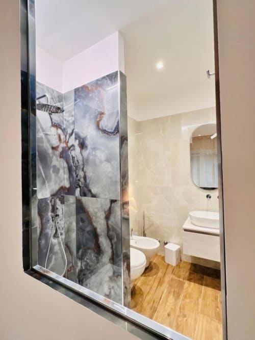 Bagno moderno a Finella Charming Rooms a Bari con doccia in marmo, sanitari bianchi e pavimento in legno