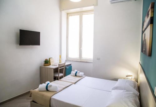 Habitación moderna en Borgo Angioino en Nápoles con camas gemelas, TV, escritorio y vistas a la ciudad