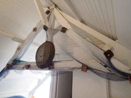 Filets de pêche et décoration vintage suspendus dans l'appartement La Brigantine à Locmaria, Belle île en mer