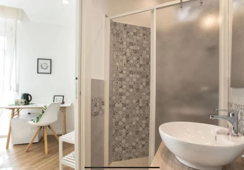Modern bathroom at Catalogna10 Rooms in Alghero with walk-in shower, vessel sink, and integrated bedroom workspace