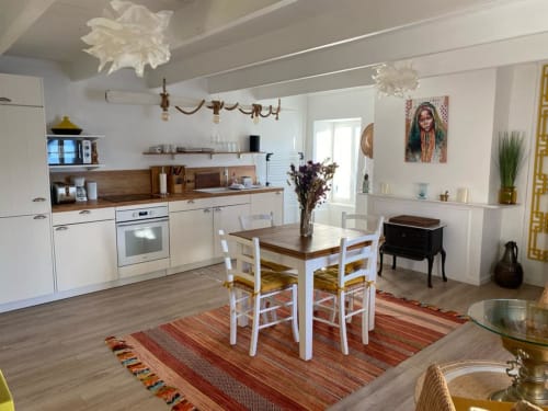 Cuisine-salle à manger moderne de l'appartement La Brigantine, Belle Île en Mer, avec mobilier blanc et accents en bois