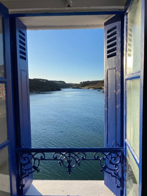 Portes bleues s'ouvrant sur une vue sereine de la mer à Locmaria Belle Île en Mer, appartement côtier français