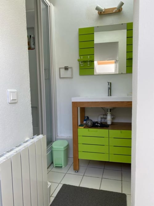 Salle de bain moderne du gîte Les Galets à Locations Loc'Maria, Belle Île en Mer, avec vanité vert citron et rangements