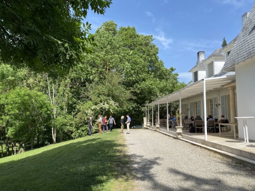 Le Domaine de Bize à Mirepoix : invités sur la terrasse avec vue sur les jardins verdoyants et les arbres