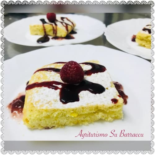 Gourmet dessert plating at Agriturismo Su Barraccu in Loceri: yellow sponge cake with white cream, dark chocolate drizzle and