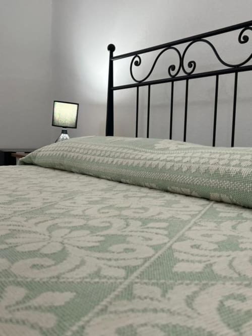 Camera da letto ad Agriturismo Su Barraccu con letto in ferro battuto ornamentale e tappeto decorativo a Loceri