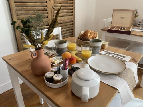 Elegant breakfast table at Hotel Le Trouville with pastries, juice, and fresh fruit overlooking Trouville sur Mer