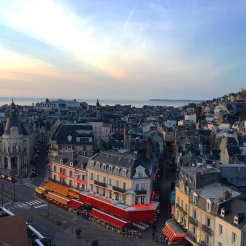Aerial view of Trouville-sur-Mer seafront with red Moulin Rouge cabaret, historic buildings, and English Channel vista
