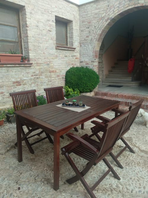 Área de comedor al aire libre en Cuartel del Montsant con mesa y sillas de madera en patio