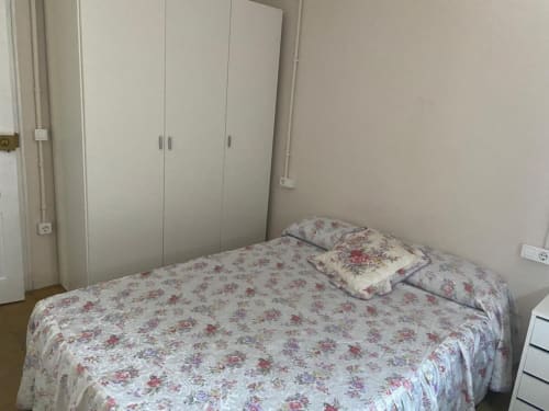 Acogedor dormitorio del apartamento Cuartel del Montsant en La Granadella con ropa de cama floral y armario blanco