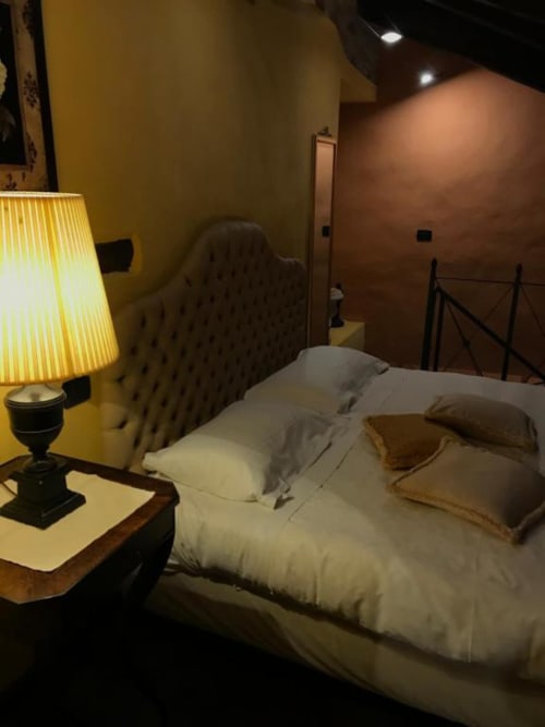 Camera accogliente presso Dimora i Manichei a Monforte d'Alba con letto, lampada gialla e illuminazione calorosa