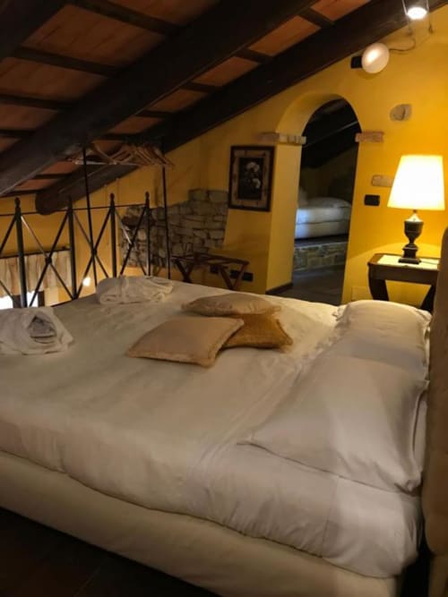 Camera da letto accogliente dell'Appartamento Orchidea presso Dimora i Manichei, Monforte d'Alba, con biancheria bianca e pareti giallo caldo