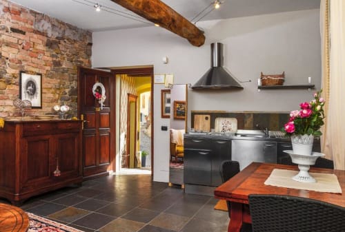Modern kitchen and dining area in Apartment Le Rose at Dimora i Manichei, Monforte d'Alba, featuring black appliances and